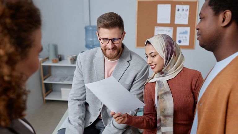 Trabalhadores Imigrantes conversando em escritório