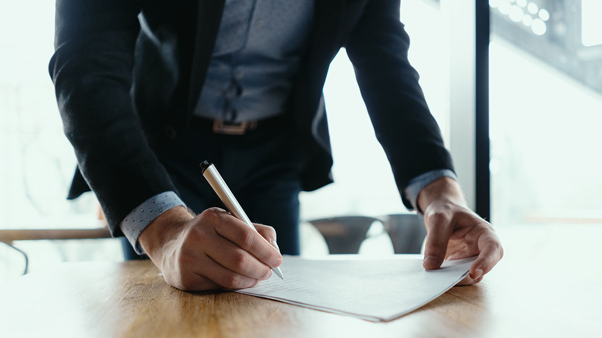 Homem assinando contrato em escritório, simbolizando a modernização da CLT e seus benefícios para trabalhadores e empresas.