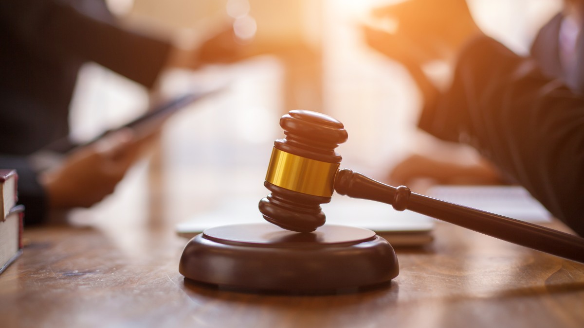 Martelo de juiz sobre mesa com documentos ao fundo representando processos trabalhistas na Justiça do Trabalho, simbolizando litígios sobre direitos trabalhistas, verbas rescisórias e relações laborais